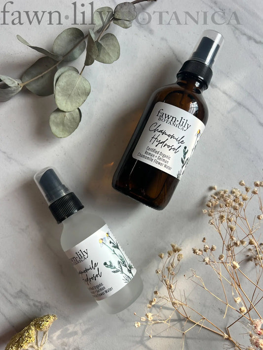 Chamomile Hydrosol by Fawn Lily Botanica in two sizes, 2 oz and 4 oz glass bottles, on a marble surface